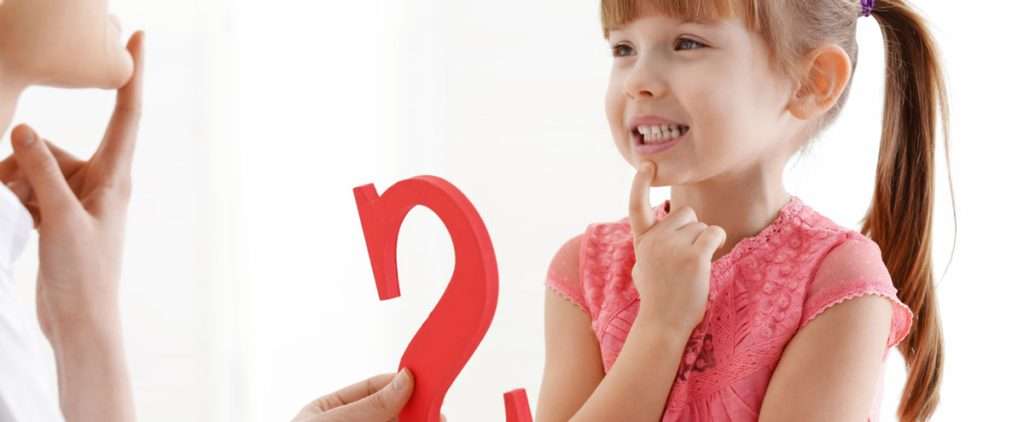 A girl practicing pediatric speech therapy activities with a speech therapist.