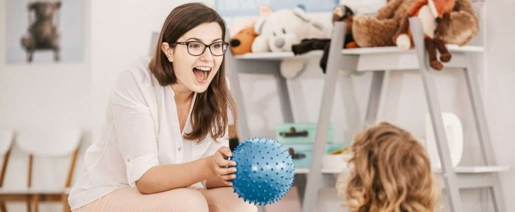 Speech pathologist using a ball in therapy, showcasing what a speech pathologist does.