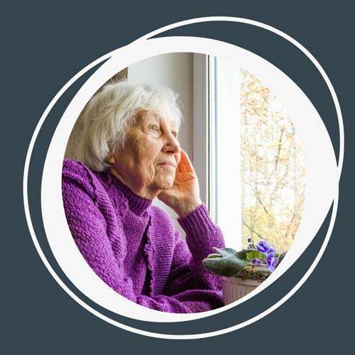 An older woman staring out the window.