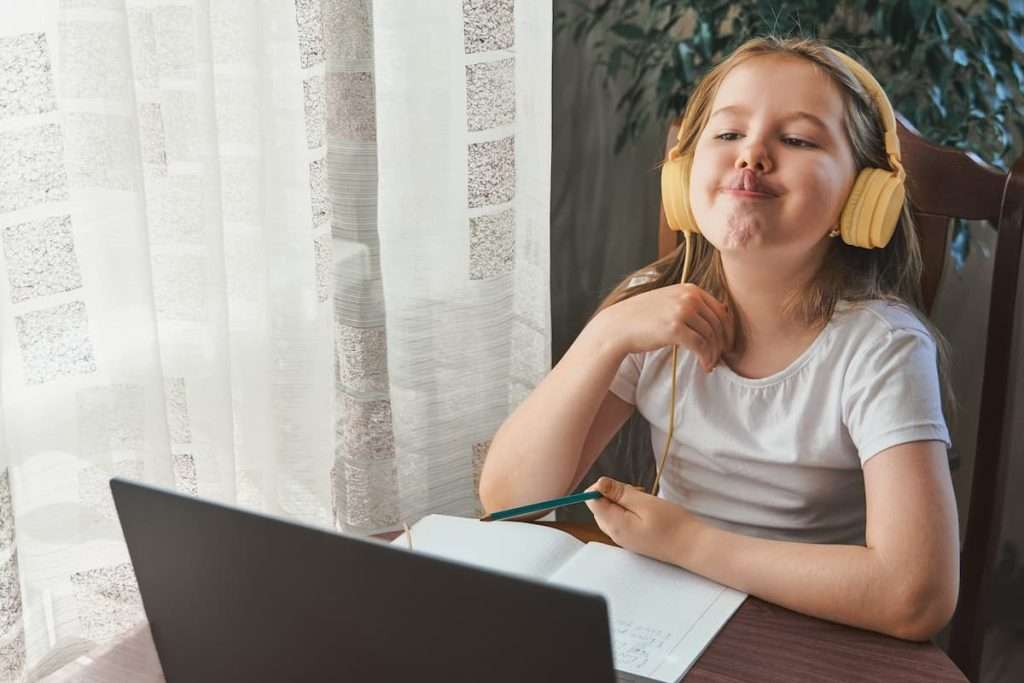 A young girl doing speech exercises during her online speech therapy session.