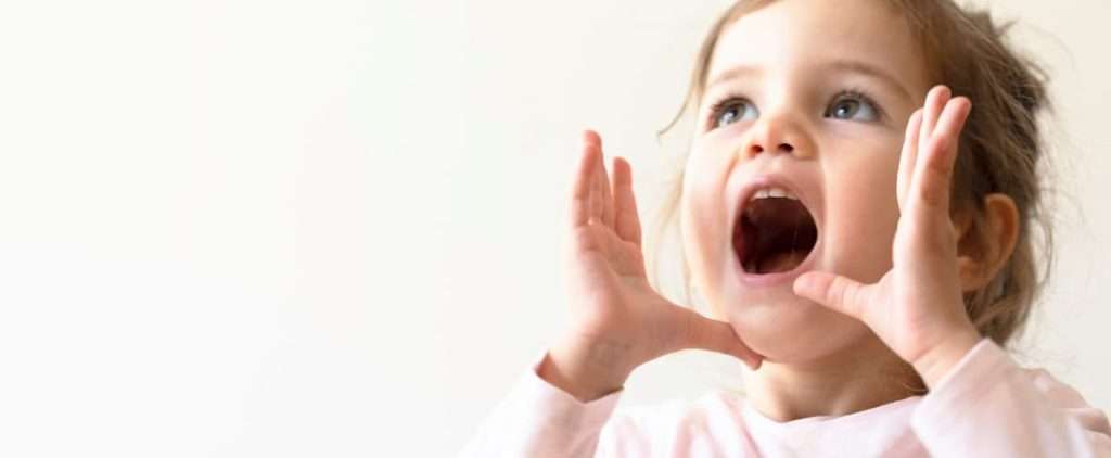 A toddler making sounds to represent early intervention speech therapy.