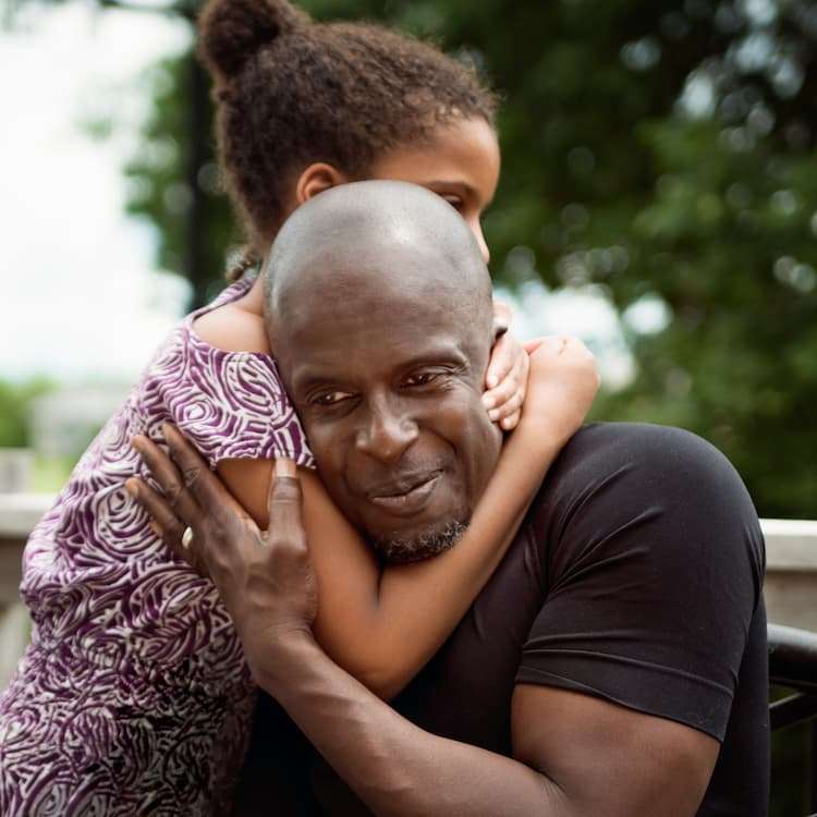 A girl hugging her dad, symbolizing a child with Autism Spectrum Disorder.